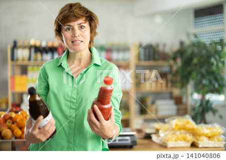 Adult woman choosing juices Adult woman choosing juices 141040806