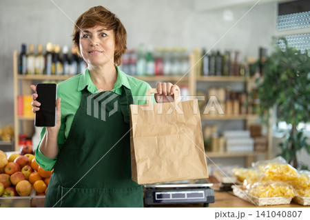 Saleswoman with phone and package Saleswoman with phone and package 141040807