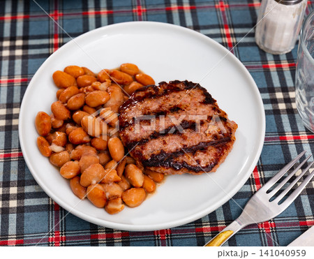 Beef burger patty served with beans Beef burger patty served with beans 141040959