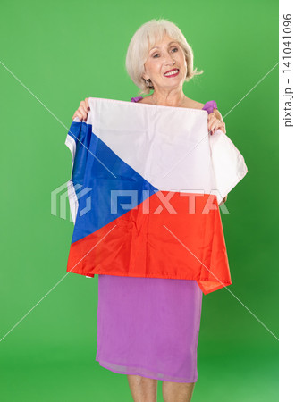 Elderly woman holding Czech flag in front of green screen Elderly woman holding Czech flag in front of green screen 141041096