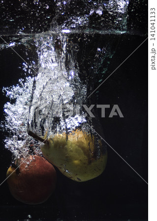 Two fresh pears splashing into clear water creating bubbles Two fresh pears splashing into clear water creating bubbles 141041133