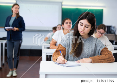 Young girl student diligently studies at school 141041155