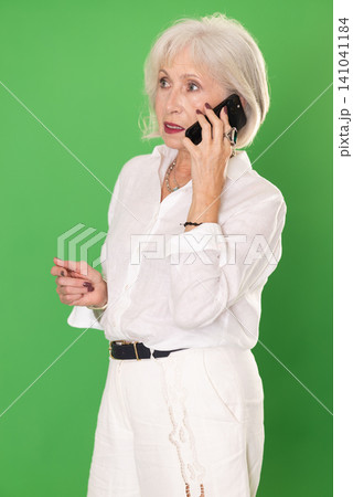 Happy woman in white clothes is talking to someone on mobile phone. Chroma key compositing Happy woman in white clothes is talking to someone on mobile phone. Chroma key compositing 141041184