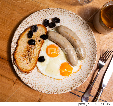 Fried eggs served with sausages for breakfast 141041245