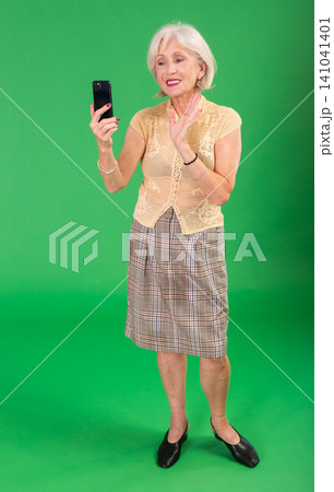 Senior woman in beige suit takes selfie 141041401