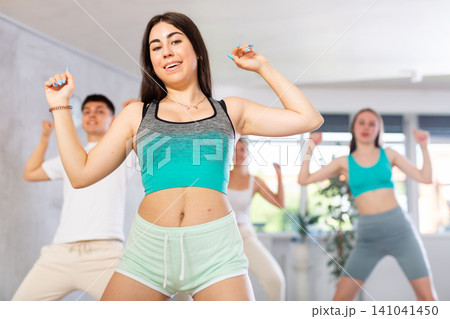 Emotional teen girl dancing krump with group in modern studio Emotional teen girl dancing krump with group in modern studio 141041450