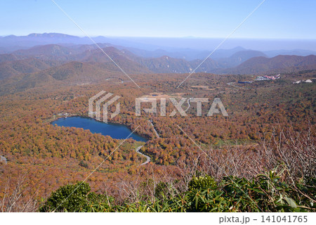 10月の栗駒山 秣岳から紅葉に埋もれる須川湖を望みさらに遠くの山々を眺める 141041765