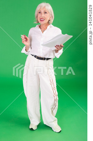 Happy elderly woman with documents in front of green screen 141041829