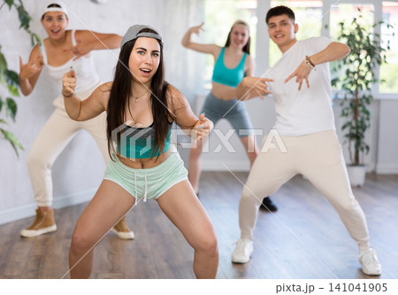 Active teenagers dancing modern dances in modern studio Active teenagers dancing modern dances in modern studio 141041905