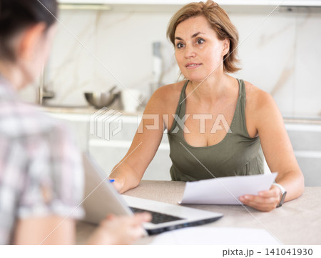 Woman manager tells girl client about specifics of design of microloan about benefits and advantages Woman manager tells girl client about specifics of design of microloan about benefits and advantages 141041930