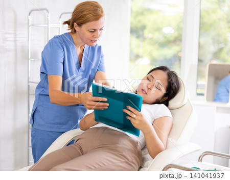 Middle-aged doctor consulting with documents Middle-aged doctor consulting with documents 141041937