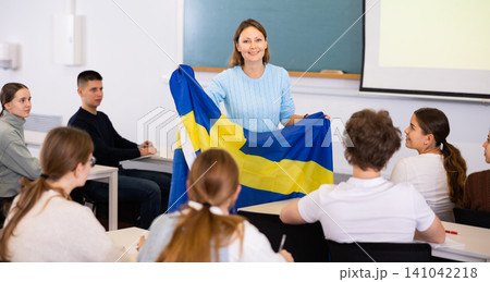 Female professor shows students flag of Sweden Female professor shows students flag of Sweden 141042218