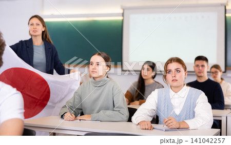 Teacher stands behind students with flag of Japan 141042257