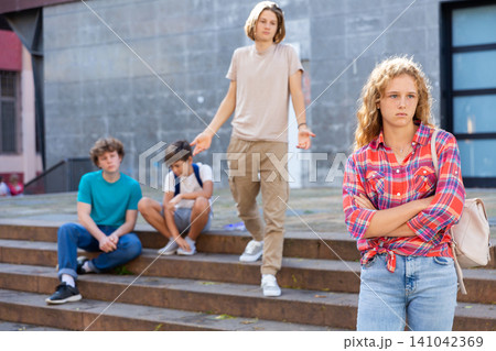 Young schoolgirl feeling upset because of quarrel with her friends Young schoolgirl feeling upset because of quarrel with her friends 141042369