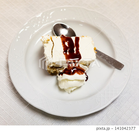 Tiramisu slice with white mascarpone cream and chocolate sauce Tiramisu slice with white mascarpone cream and chocolate sauce 141042377