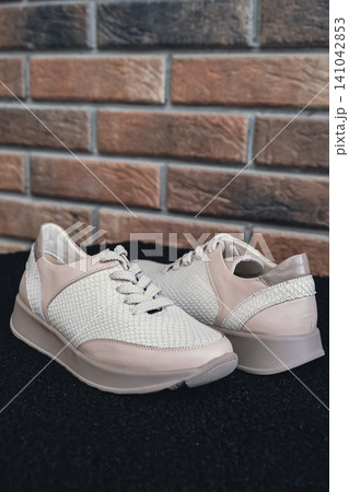 Fresh beige leather sneakers without brand marks displayed. For design templates online shops and sustainability-themed marketing. Clean blank sneakers Fresh beige leather sneakers without brand marks displayed. For design templates online shops and sustainability-themed marketing. Clean blank sneakers 141042853