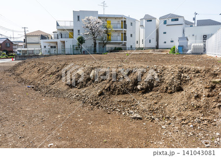 住宅街の更地に残る段差と砕石混じりの地面 住宅街の更地に残る段差と砕石混じりの地面 141043081