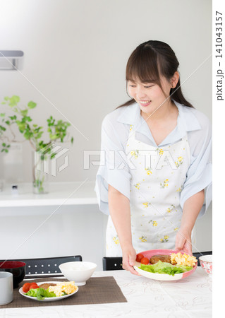 食卓に手料理を並べる母親・家族の夕食や家庭料理の準備をする女性 141043157