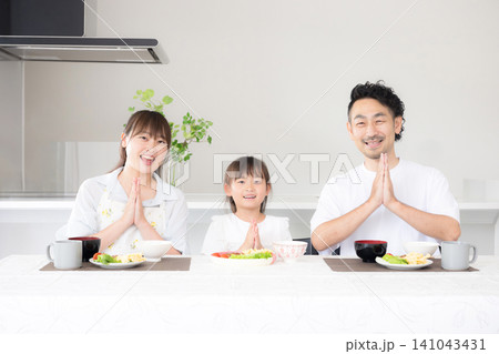 いただきますをしてダイニングで座る食事を始める親子3人の家族・食育や家族団らんのカメラ目線イメージ いただきますをしてダイニングで座る食事を始める親子3人の家族・食育や家族団らんのカメラ目線イメージ 141043431