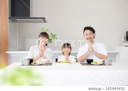 いただきますをしてダイニングで座る食事を始める親子3人の家族・食育や家族団らんのカメラ目線イメージ いただきますをしてダイニングで座る食事を始める親子3人の家族・食育や家族団らんのカメラ目線イメージ 141043432