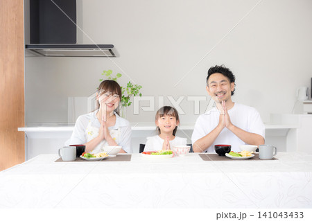 いただきますをしてダイニングで座る食事を始める親子3人の家族・食育や家族団らんのカメラ目線イメージ いただきますをしてダイニングで座る食事を始める親子3人の家族・食育や家族団らんのカメラ目線イメージ 141043433