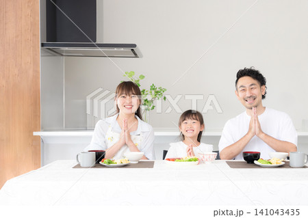 いただきますをしてダイニングで座る食事を始める親子3人の家族・食育や家族団らんのカメラ目線イメージ いただきますをしてダイニングで座る食事を始める親子3人の家族・食育や家族団らんのカメラ目線イメージ 141043435