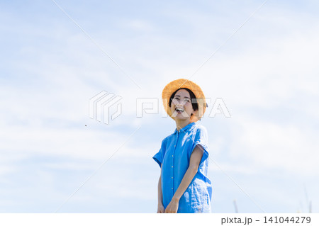 麦わら帽子をかぶって深呼吸をする若い女性 ライフスタイルイメージ 麦わら帽子をかぶって深呼吸をする若い女性 ライフスタイルイメージ 141044279