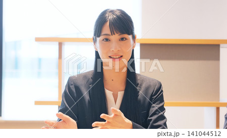 カメラ目線でビデオ通話する女性 カメラ目線でビデオ通話する女性 141044512