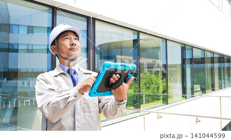 タブレットを使ってビルを点検するエンジニア タブレットを使ってビルを点検するエンジニア 141044599