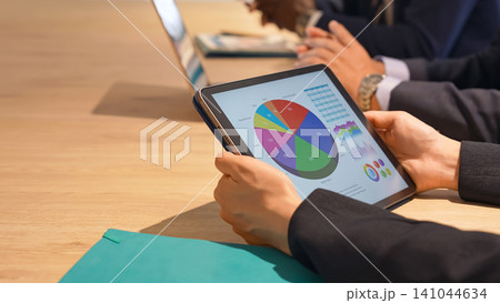 タブレット画面を見ながら会議するビジネスパーソン タブレット画面を見ながら会議するビジネスパーソン 141044634