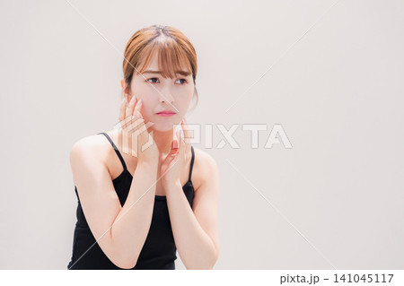 お肌の不調に悩む明るい髪色の若い女性 お肌の不調に悩む明るい髪色の若い女性 141045117