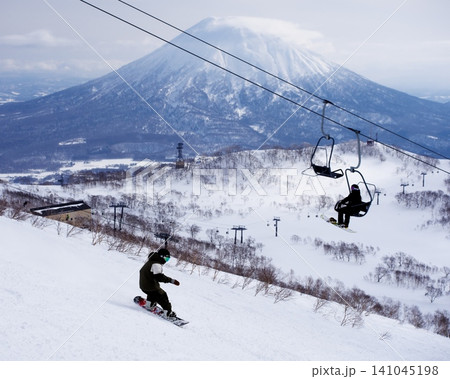 ニセコビレッジスキーリゾートの羊蹄山を背景にワンダーランドを滑るスノーボーダー ニセコビレッジスキーリゾートの羊蹄山を背景にワンダーランドを滑るスノーボーダー 141045198