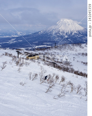ニセコビレッジスキーリゾート 羊蹄山を背景にワンダーランドを滑るスキーヤー ニセコビレッジスキーリゾート 羊蹄山を背景にワンダーランドを滑るスキーヤー 141045359