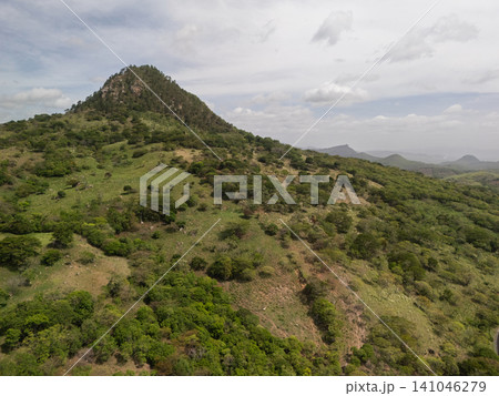 Mountain view with greenery and hills under a cloudy sky Mountain view with greenery and hills under a cloudy sky 141046279