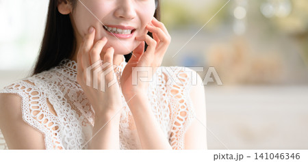 顔に手を当てる女性 141046346