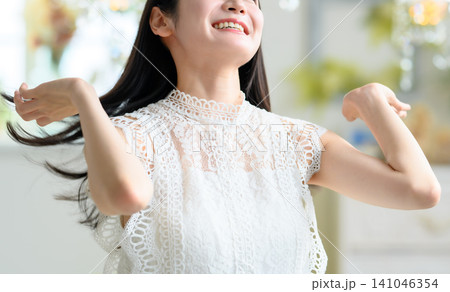 白いレースの服を着て髪をかき上げる女性 141046354