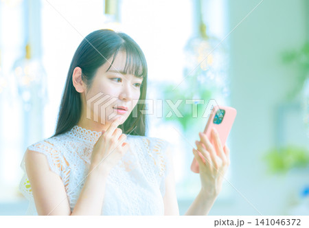 スマートフォンに注目する女性 スマートフォンに注目する女性 141046372
