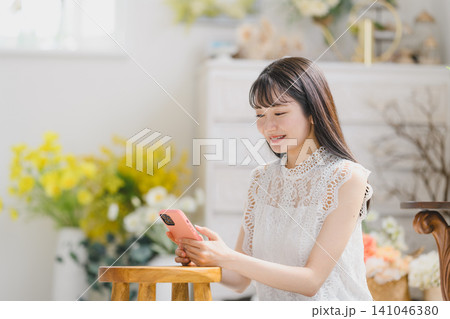 笑顔でスマートフォンを見る女性 笑顔でスマートフォンを見る女性 141046380