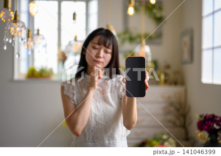 スマートフォンを手に持つ女性 スマートフォンを手に持つ女性 141046399
