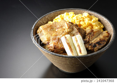 炒り卵と焼き長葱と炭火焼きチキン丼を黒背景で撮影 炒り卵と焼き長葱と炭火焼きチキン丼を黒背景で撮影 141047368