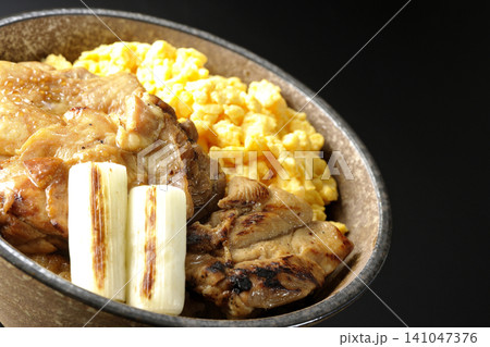 炒り卵と焼き長葱と炭火焼きチキン丼を黒背景で撮影 141047376
