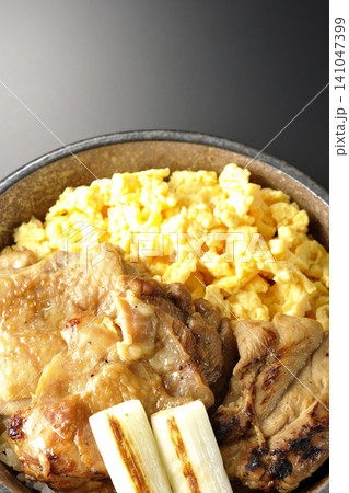 炒り卵と焼き長葱と炭火焼きチキン丼を黒背景で撮影 141047399