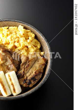 炒り卵と焼き長葱と炭火焼きチキン丼を黒背景で撮影 炒り卵と焼き長葱と炭火焼きチキン丼を黒背景で撮影 141047402