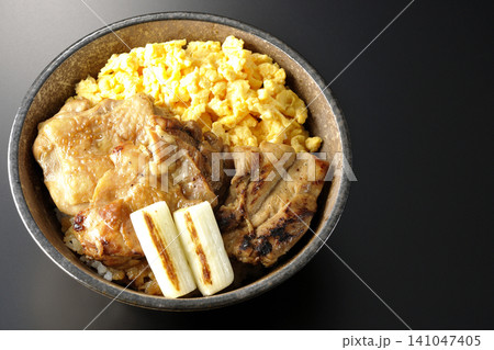 炒り卵と焼き長葱と炭火焼きチキン丼を黒背景で撮影 141047405