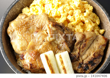 炒り卵と焼き長葱と炭火焼きチキン丼を黒背景で撮影 炒り卵と焼き長葱と炭火焼きチキン丼を黒背景で撮影 141047406