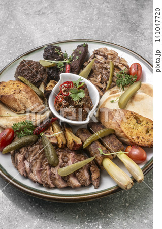mixed grilled meat bbq gourmet big plate on restaurant table 141047720