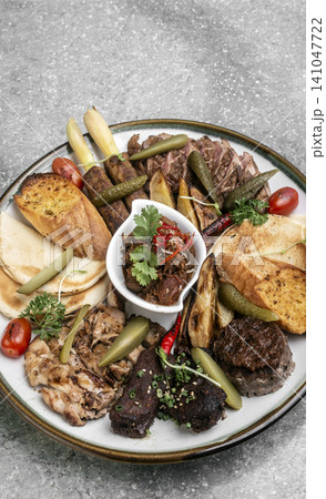 mixed grilled meat bbq gourmet big plate on restaurant table 141047722