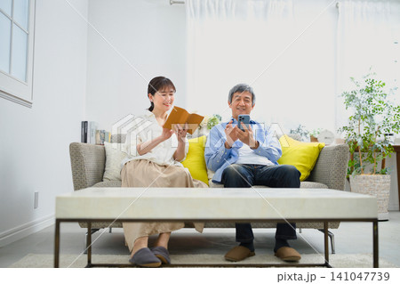 ソファーに座ってリラックスして過ごすシニアの夫婦 ソファーに座ってリラックスして過ごすシニアの夫婦 141047739