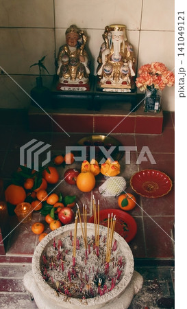 Smoke rising from incense in a Taoist altar with auspicious fruits and food displayed as offering for Lunar New Year showing authentic culture and tradition. Hong kong 141049121