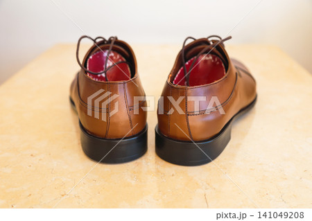 Pair of new brown leather men's dress shoes neatly arranged on a clean surface Pair of new brown leather men's dress shoes neatly arranged on a clean surface 141049208